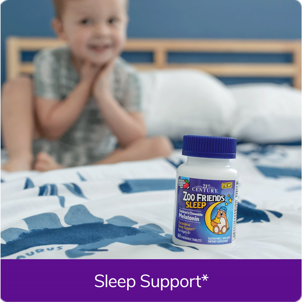 Boy sitting on bed next to Zoo Friends Sleep vitamins.