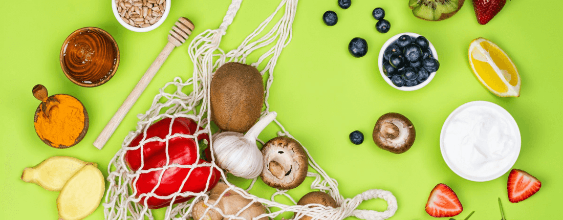 Assorted fruits and vegetables on a green background.