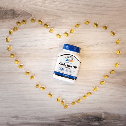 A bottle of 21st Century Norwegian Cod Liver Oil 400 mg softgels laying on a wood floor surrounded by softgels in the shape of a heart.