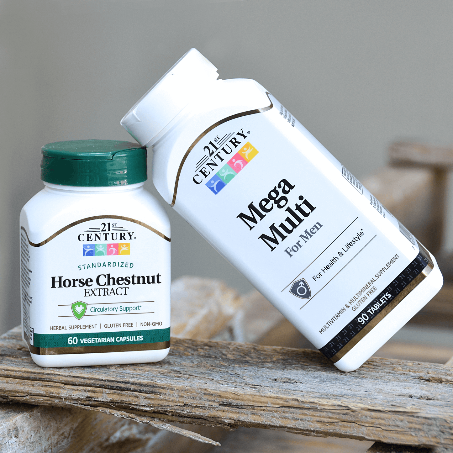 A bottle of Mega Multi Men's Multivitamin Multimineral tablet leaning on a bottle of 21st Century Horse Chestnut Extract vegetarian capsules on a piece of old wood.