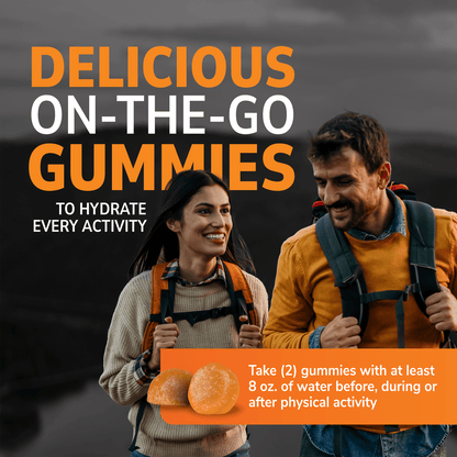 A happy woman and man smiling at each other while hiking wearing backpacks, two electrolyte gummies and the words delicious on the go gummies to hydrate every activity, and take two gummies with at least 8 ounces of water before, during or after physical activity.