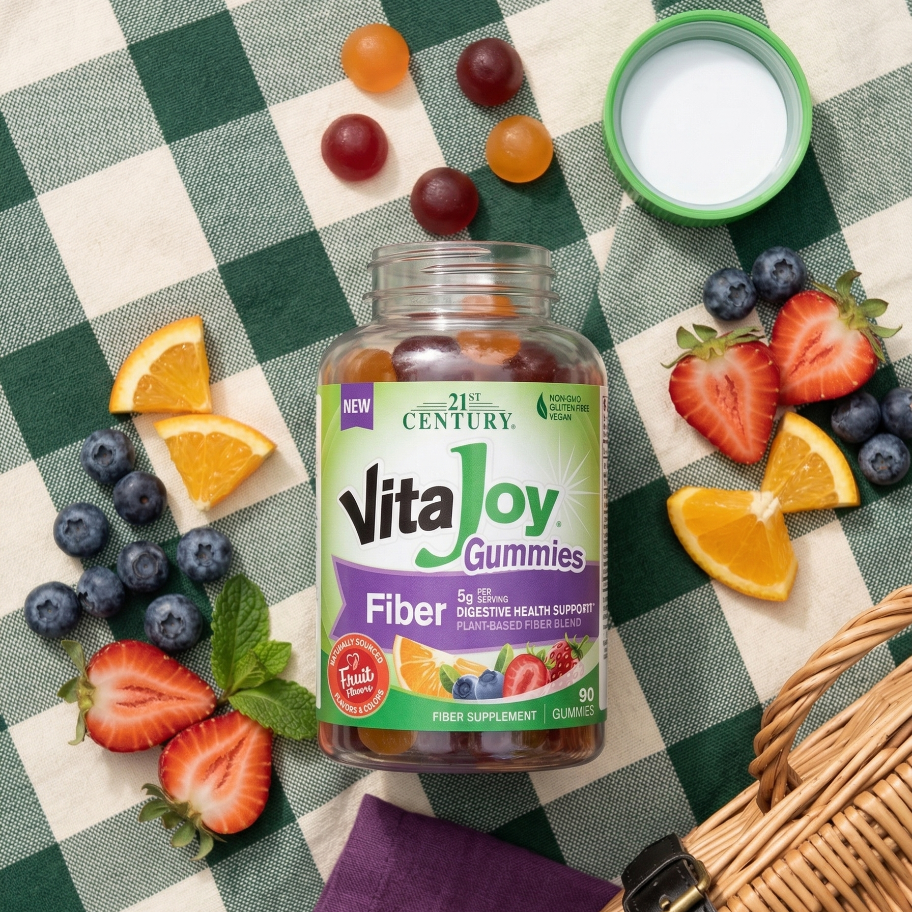 VitaJoy Fiber Gummies laying on picnic blanket with gummies and fruit around bottle.