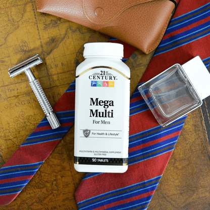 Top view of a bottle of 21st Century Mega Multi Mens Multivitamin and Multimineral tablets a men's razor, a bottle of cologne, a tie and leather eye glass case.