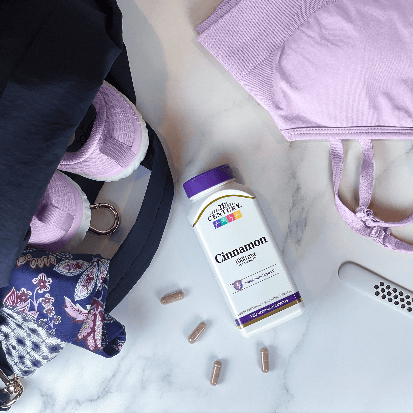 A bottle of 21st Century Cinnamon 1000 mg vegetarian capsules next to sports bra, running shoes, and a rolled up yoga mat in a gym bag.