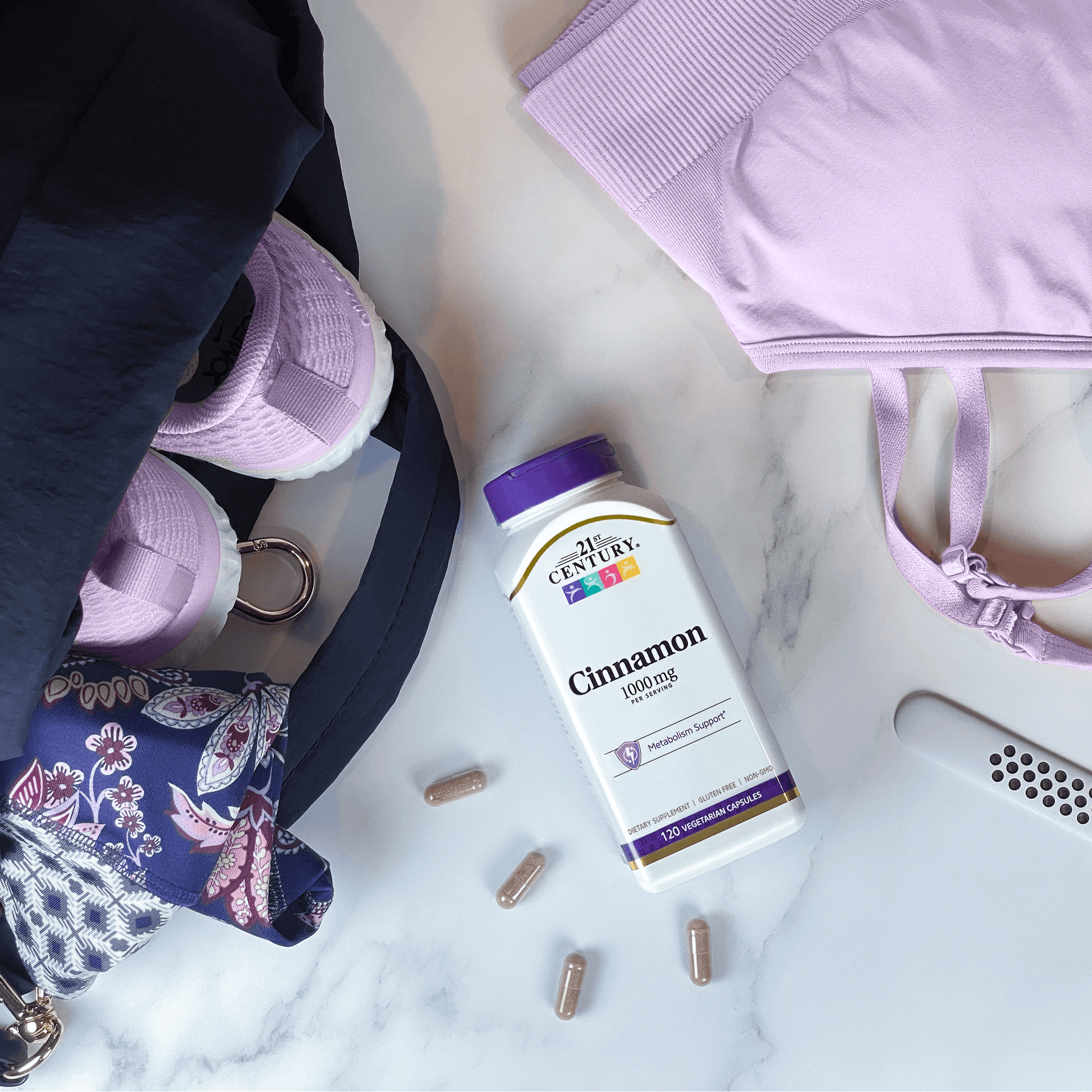 A bottle of 21st Century Cinnamon 1000 mg vegetarian capsules next to sports bra, running shoes, and a rolled up yoga mat in a gym bag.