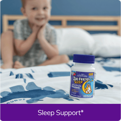 Boy sitting on bed next to Zoo Friends Sleep vitamins.