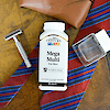 Top view of a bottle of 21st Century Mega Multi Mens Multivitamin and Multimineral tablets a men's razor, a bottle of cologne, a tie and leather eye glass case.