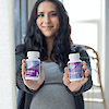 A pregnant woman holding a bottle of 21st Century One Daily Prenatal Multivitamin Plus DHA tablets and softgels.
