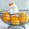 A bottle of 21st Century Vitamin C 500 mg chewable tablets sitting in a wire bowl of oranges.