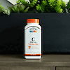 A bottle of 21st Century Vitamin C 1000 mg with Rose Hips tablets with a potted plant in the background.