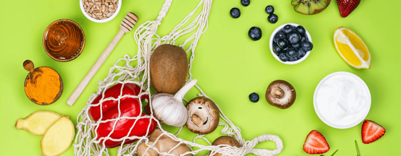 Assorted fruits and vegetables on a green background.