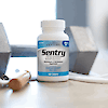 A bottle of 21st Century Sentry Senior Men's 50+ Multivitamin and Multimineral tablets on a table with a dumbbell in the background.