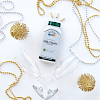 A bottle of 21st Century Milk Thistle Extract vegetarian capsules laying on white background with silver and gold marti gras beads and two champagne glasses.