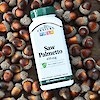 A bottle of 21st Century Saw Palmetto 450 mg vegetarian capsules laying on acorns.