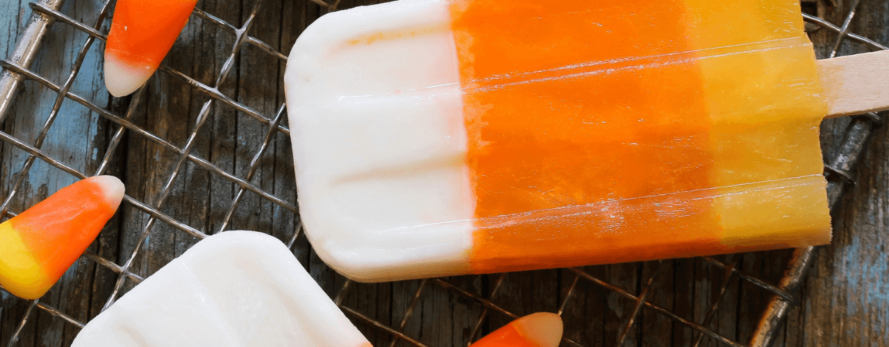 Top view of Halloween candy corn and candy corn popsicles on a kitchen counter.
