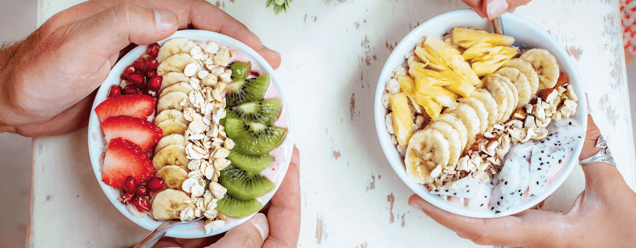 Bowls filled with delicious fruit, granola and yogurt.